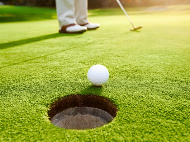 putting - hitting golf ball on the golf course